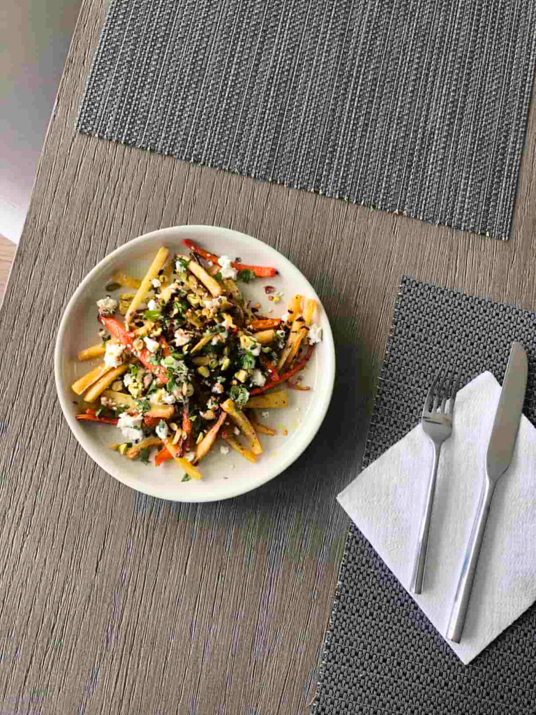 table set with honey roasted carrots and parsnips and waffle fries